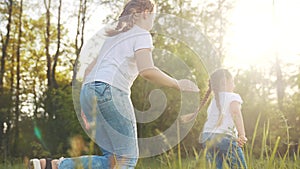 girls kid dream together run in the park at sunset. happy family people in the park concept. two sisters playing catch