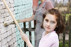 Girls kids paint the walls with a roller