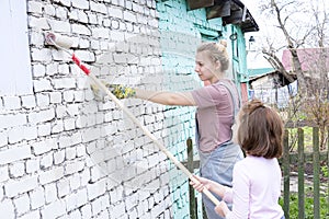 Girls kids paint the walls with a roller