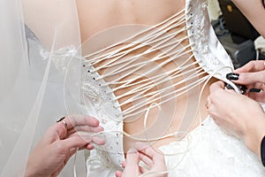 Girls lace up a dress of the bride photo