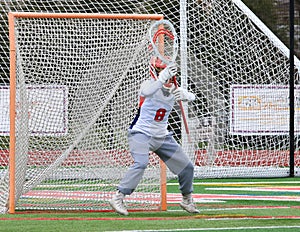 Girls lacrosse goalie guarding the goal during a game