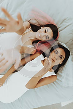 Girls Laying On A Bed In Veils. Posing Concept.