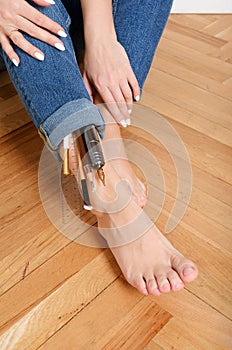 Girls legs sitting in jeans on the floor with many  brushes