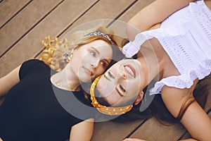 The girls are on the pier near the beach. Girls smile, sunbathe. Summer vacations, girlfriends, traveling, vacations with friends