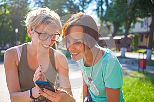 The girls look at the phone.