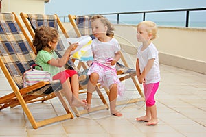 Girls in lounge on veranda, considering drawing