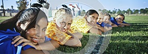 Girls Lying In Row On Soccer Field