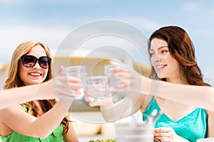 Girls making a toast in cafe on the beach