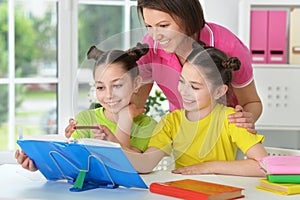 Girls and mother doing homework