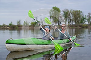 Girls with oars in the boat. Mom and daughter are floating in a boat