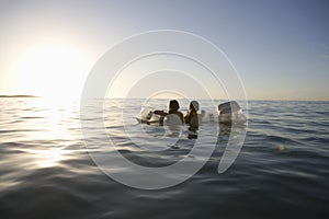 Girls Paddling Out To Sea On Air Mattress