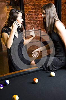 Girls on phone in poolroom