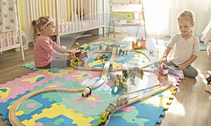 Girls play with a wooden set