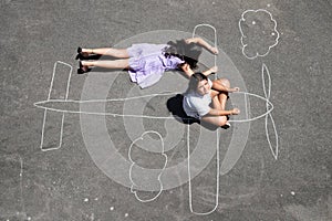 Girls playing in a chalk airplane