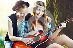 Girls playing guitar in the park