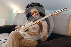 Girls playing jazz music. Woman musician with bass guitar at home