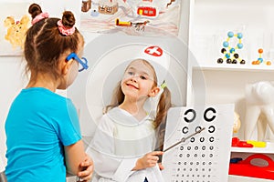 Girls playing oculist and patient at medical room