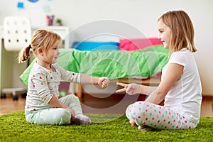 Girls playing rock-paper-scissors game at home