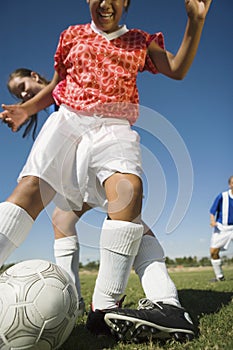 Girls playing soccer, one tackling another