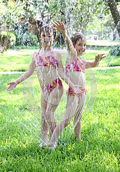 Girls Playing in Sprinkler