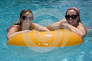 Girls in Pool Floating on Lifesaver