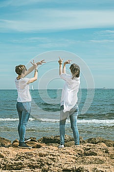 Girls practicing yoga poses on the beach. Healthy Lifestyle