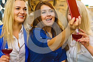 Girls in pub club taking self photo with phone