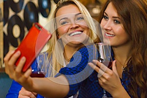 Girls in pub club taking self photo with phone