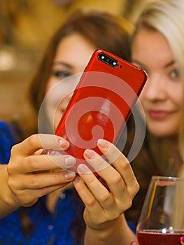 Girls in pub club taking self photo with phone