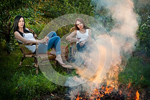 Girls with red wine glasses near bonfire