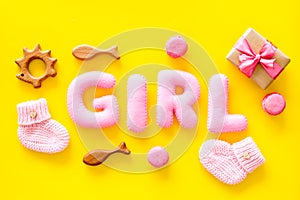 Girls`s birthday concept. Pink baby set with gift box on yellow backgound top view