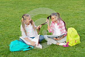 Girls school pupils doing homework together on fresh air, playful children concept