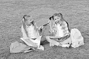 Girls school pupils doing homework together on fresh air, playful children concept