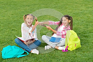 Girls school pupils doing homework together on fresh air, sisters rivalry concept