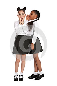 Girls in school uniform gossiping on background