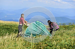 Girls set up tent on top mountain. Camping skills concept. Camping and hiking. In middle of nowhere. Temporary housing