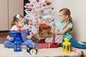 Girls share presented New Year gifts at the Christmas tree