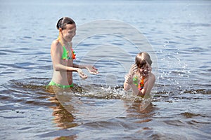 Girls sister fun splashing in the river. Laughter, joy, pleasure