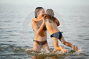 Girls sisters have fun bathing in the sea