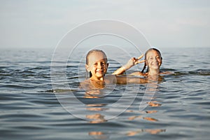 Girls sisters have fun bathing in the sea