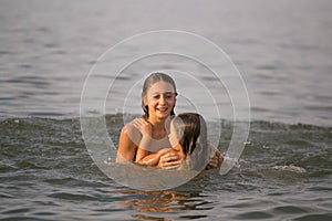 Girls sisters have fun bathing in the sea