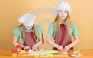 Girls sisters having fun ginger dough. Homemade cookies best. Kids baking cookies together. Kids aprons and chef hats