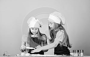 Girls sisters having fun ginger dough. Kids baking cookies together. Kids aprons and chef hats cooking. Homemade cookies