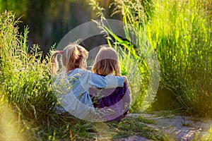 Girls sit having embraced ashore