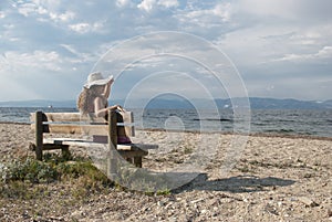 Girls sitting on a bench looking at the sea