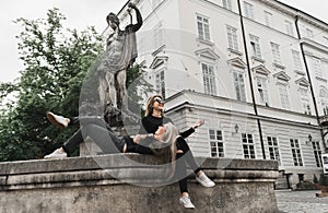 Girls sitting at the fountain. Summer holidays concept