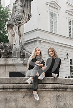 Girls sitting at the fountain. Summer holidays concept