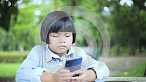 Girls sitting watching mobile phones in the park