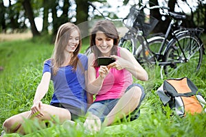 Girls with smartphone on a glade