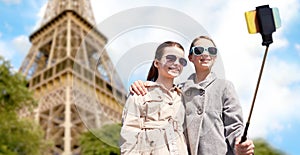 Girls with smartphone selfie stick at eiffel tower